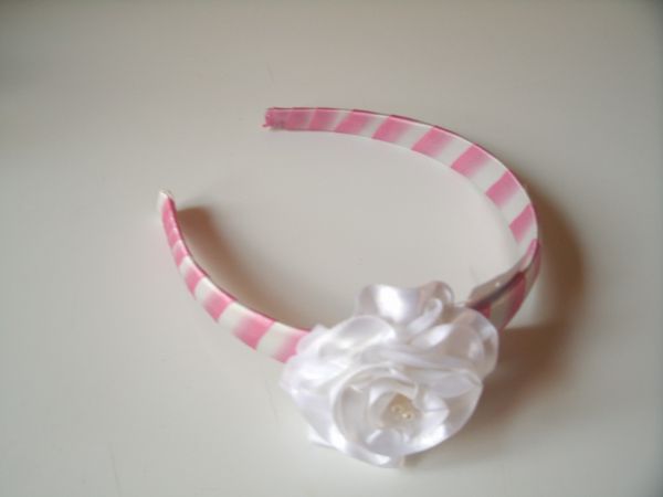 Arquinho rosa com flor branca
